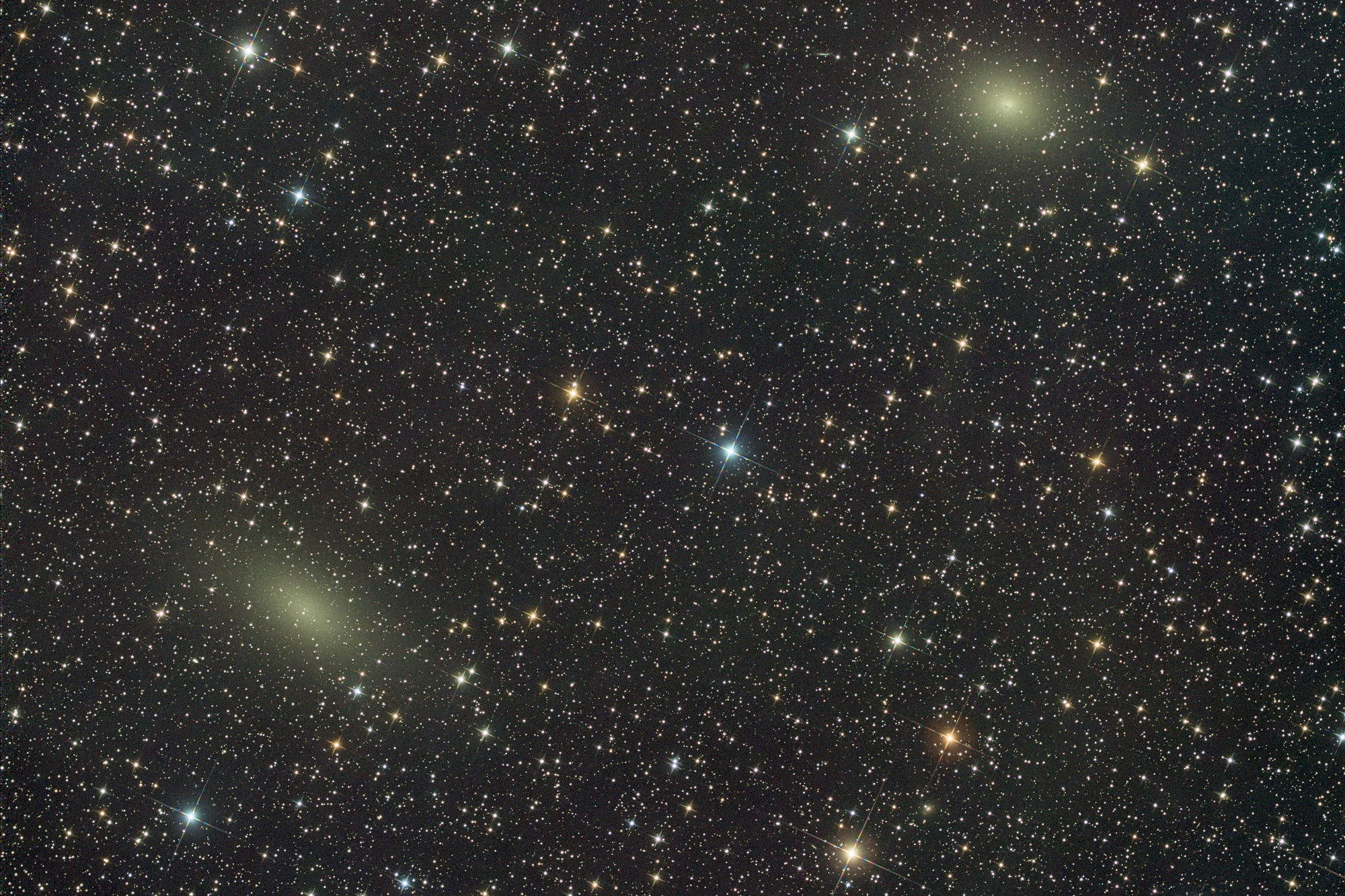 Galaxy NGC 147 on the left is a dwarf spherical galaxy about 2.58 Mly away in the constellation of Cassiopeia. NGC 147 is a member of the Local Group of galaxies and a satellite galaxy of the Andromeda Galaxy (M31). It forms a physical pair with the near right galaxy NGC 185, another distant satellite of M31.